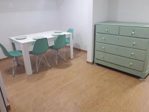 uma mesa e quatro cadeiras ao lado de uma cómoda em Sesimbra Beach Fonte House em Sesimbra