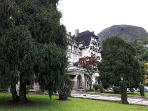 ein großes weißes Haus mit Bäumen davor in der Unterkunft Loft particular - Palácio Quitandinha in Petrópolis