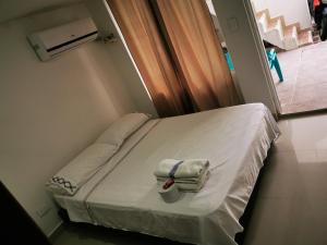 a hospital bed with towels on it in a room at Bull Shark Posada in San Andrés