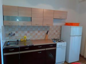 a small kitchen with a sink and a refrigerator at Apartments Anđelka in Pag
