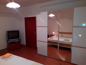 een kamer met een slaapkamer met een bed en een televisie bij Apartments Anđelka in Pag