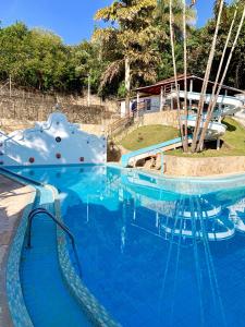 uma grande piscina com água azul num resort em Hotel Ponta do Morro em Tiradentes