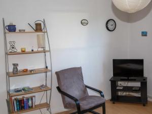 uma sala de estar com uma cadeira e uma televisão em 080 Ferienwohnungen Neuengroden em Wilhelmshaven