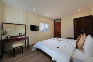 Schlafzimmer mit einem Bett, einem Schreibtisch und einem Spiegel in der Unterkunft Spoon Hotel in Hanoi