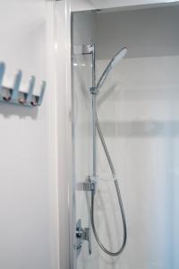 um chuveiro com uma porta de vidro na casa de banho em Kaka Point Views Apartment 1 em Kaka Point