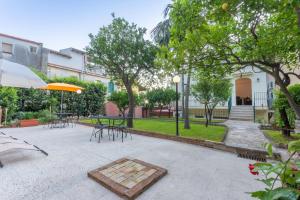 a patio with a table and chairs and an umbrella at Villa Valverde Apartments e B&B in Taormina