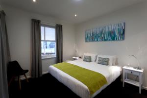 una camera da letto con un letto grande con una coperta verde di Quest Savoy a Hobart