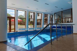 a swimming pool in a building with windows at Mountain View Aparthotel in Bansko