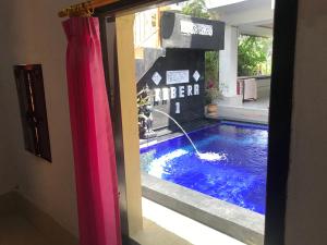 a swimming pool in a house with a pink curtain at Kabera Bungalow Ubud in Ubud