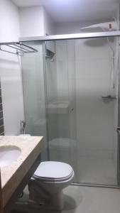 a bathroom with a toilet and a glass shower at Park Veredas in Rio Quente