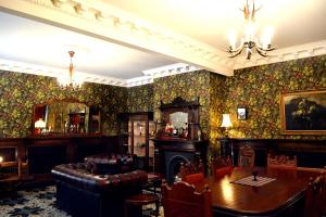 a dining room with a table and a fireplace at Theatre Royal Hotel in Kumara