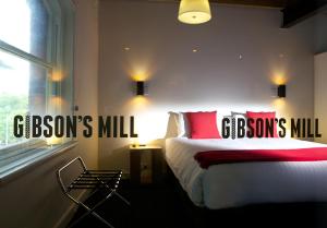 sypialnia z łóżkiem z czerwonymi poduszkami i oknem w obiekcie Sullivans Cove Apartments w mieście Hobart