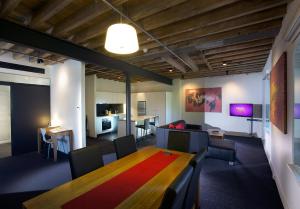 een kamer met een tafel en stoelen en een keuken bij Sullivans Cove Apartments in Hobart