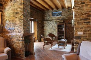 sala de estar con pared de piedra en Casa Rural Soutomoro, en Loiba