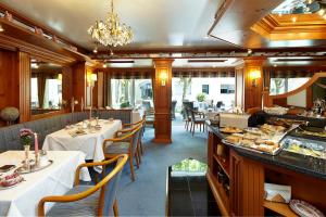 a restaurant with tables and chairs and a buffet at Hotel Scherf in Bad Lippspringe