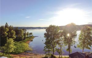 a view of a lake with the sun shining on the water at 2 Bedroom Beautiful Home In Fristad in Tämta
