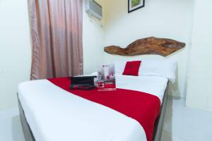 巴科洛德RedDoorz near New Government Center的一间卧室，有两张床，床单为红色和白色