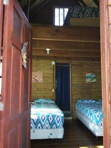 a room with two beds in a log cabin at Rancho Estero in Santa Catalina