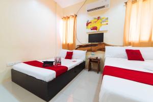 a hotel room with two beds and a television at RedDoorz near New Government Center in Bacolod