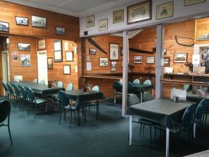 a dining room with tables and chairs and pictures on the walls at Centennial Hotel Gulgong in Gulgong
