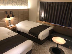 Postel nebo postele na pokoji v ubytování Kobe Luminous Hotel Sannomiya
