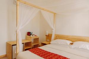 ein Schlafzimmer mit einem Himmelbett in der Unterkunft WAVE SOUND by 3S Maldives in Maradhoofeydhoo