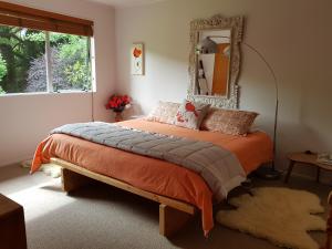 a bedroom with a bed with a mirror on the wall at Haurata High Country Retreat/walks in Gisborne