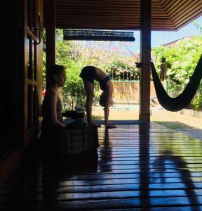 a person bending over on a porch with a woman at Baan Mai Sak in Pai