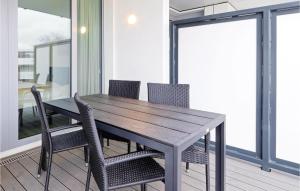 a wooden table and chairs in a room with windows at Highend Travemünde - Whg 203 in Travemünde
