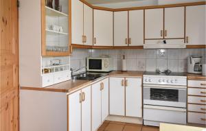 a kitchen with white cabinets and white appliances at Beautiful Home In Borrby With House Sea View in Borrby