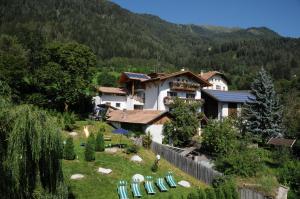a resort with lawn chairs and a building at Chalet & Appartement Zingerlehof Trens in Campo di Trens