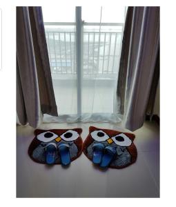 deux hiboux portant des chaussures assis devant une fenêtre dans l'établissement 2 Bed Room Amazing Sea View Condo 80sqm Fast Internet, à Jakarta