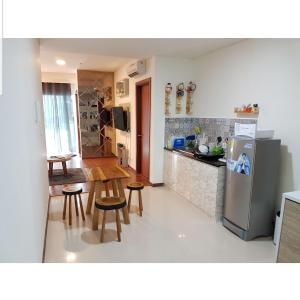 cocina con nevera, mesa y sillas en 2 Bed Room Amazing Sea View Condo 80sqm Fast Internet en Yakarta