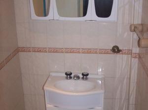 a bathroom with a white sink and two windows at Apart Hotel Monaco in Santa Teresita +5 photos