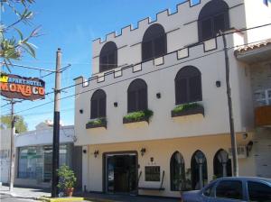 a white building with windows and plants on it at Apart Hotel Monaco in Santa Teresita