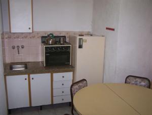 a small kitchen with a table and a refrigerator at Apart Hotel Monaco in Santa Teresita