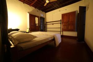 a bedroom with a bed and a wooden door at Aqualillies Water Front Heritage Homestay in Kumarakom