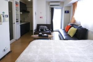 um quarto com uma cama, um sofá e uma mesa em Luft 603 em Osaka