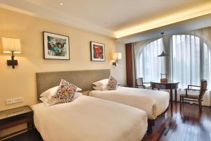 a hotel room with two beds and a table at SSAW Boutique Hotel ShanghaiHongkou in Shanghai