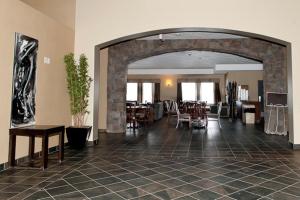 a lobby with an archway and tables and chairs at Paradise Inn and Suites in Valleyview