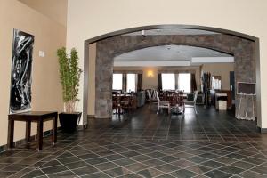 um átrio com um arco e mesas e cadeiras em Paradise Inn and Suites em Valleyview