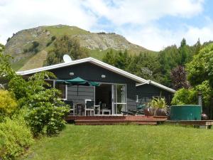 a black house with a mountain in the background at Haurata High Country Retreat/walks in Gisborne