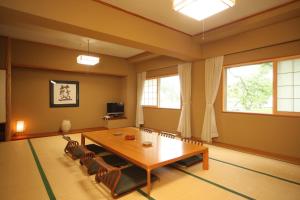 a dining room with a wooden table and chairs at Towadako Lake View Hotel in Kosaka