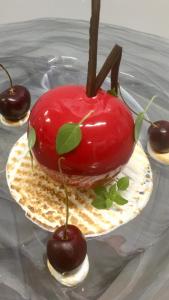 a fake red apple on a plate with cherries at Logis Le Relais de la Voie Sacrée in Issoncourt