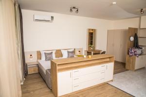 a bedroom with a bed and a desk in it at Allure Beach Resort Aparthotel in Primorsko +42 photos