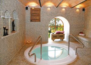 a bathroom with a tub in a room with a window at Hotel Golf Can Rafel in Corbera de Llobregat