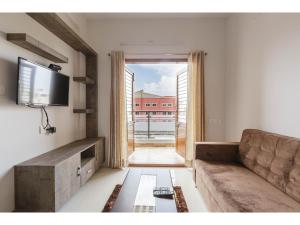 un soggiorno con divano e una grande finestra di Olive Serviced Apartments HSR Layout a Bangalore