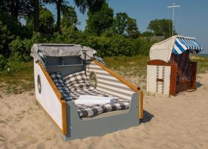 ジールクスドルフにあるSchlafstrandkorb Nr.2の浜辺の砂浜にあるおもちゃのボート