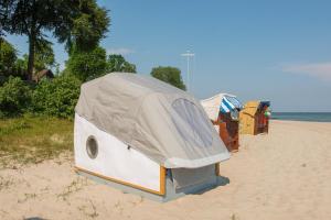 a camper on the beach with a tent on it at Schlafstrandkorb Nr.2 in Sierksdorf
