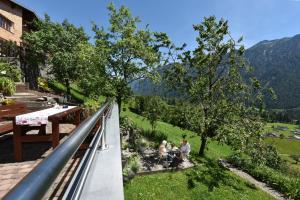 a group of people sitting in the grass on a balcony at Mottnerhof in Braz